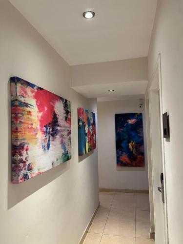 three paintings hanging on a wall in a hallway at Hotel Arribo in Lagos de Moreno