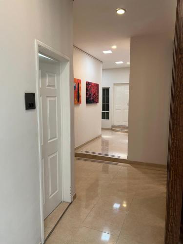 un pasillo con una puerta blanca y una habitación con pinturas en Hotel Arribo, en Lagos de Moreno