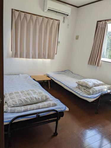 a room with two beds in it with a window at Unbi Stay -SEVEN Hotels and Resorts- in Nakijin