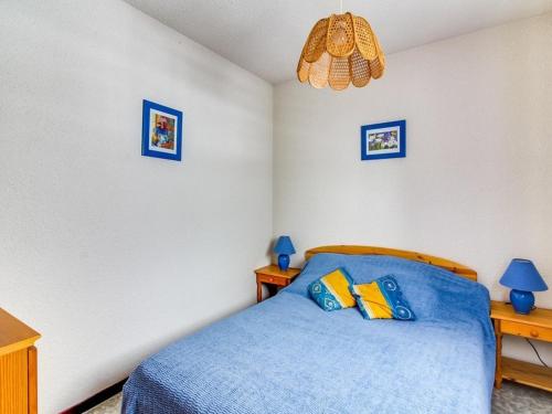 - une chambre avec un lit bleu et 2 oreillers dans l'établissement Appartement T2 lumineux avec balcon, parking privé à Cauterets, proche centre et télécabine - FR-1-401-28, à Cauterets