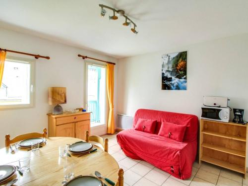 un salon avec un canapé rouge et une table dans l'établissement Chalet duplex 6 pers avec parking à 600m des remontées, proche commerces et navette gratuite - FR-1-401-42, à Cauterets