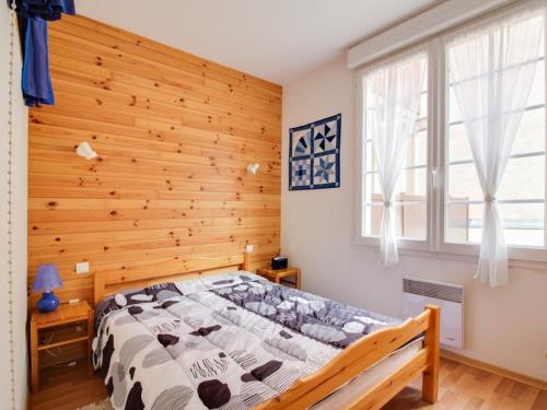 un lit dans une chambre avec un mur en bois dans l'établissement Appartement T2 avec terrasse, coin nuit, parking et proximité télécabine - 4 pers. - FR-1-401-66, à Cauterets