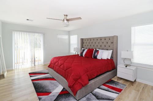 Schlafzimmer mit einem Bett mit einer roten Decke und einem Teppich in der Unterkunft PEERLESS RETREAT - Minutes from Downtown Houston in Houston