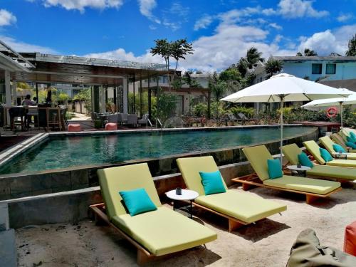 蒙舒瓦西的住宿－Wonders Beach Boutique Hotel，游泳池旁的一排躺椅