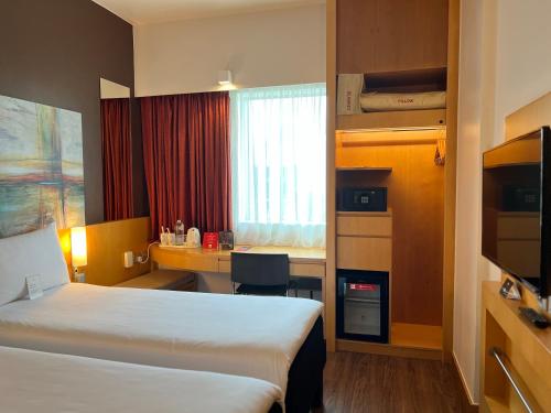 a hotel room with a bed and a desk at Ibis One Central - World Trade Centre Dubai in Dubai