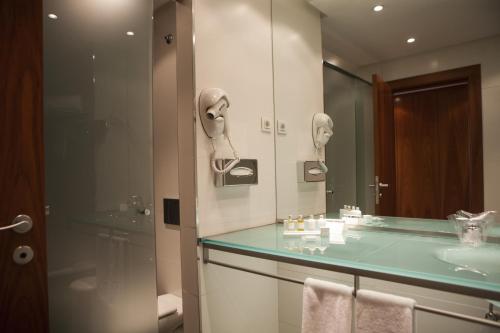 een badkamer met een wastafel en een spiegel bij Parador de La Granja in La Granja de San Ildefonso