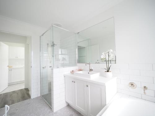 a white bathroom with a sink and a shower at New Home~close to Airport & Swan Valley inc B/fast 1st Morning~ in Perth