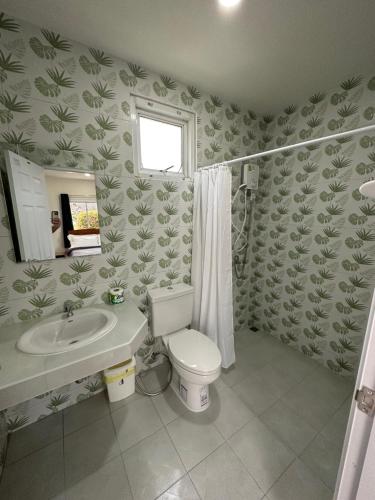 a bathroom with a toilet and a sink at Plearn Khaoyai Resort in Mu Si