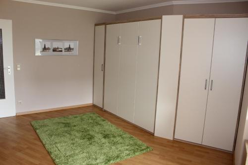 Habitación con armarios blancos y alfombra verde. en Lord Nelson 113, en Döse