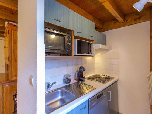 une cuisine avec un évier et un micro-ondes dans l'établissement Duplex T2 Cabine 45m², 6 pers, skis, parking, lave-linge, lave-vaisselle - FR-1-403-86, à Barèges