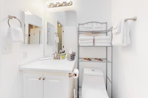 Baño blanco con lavabo y aseo en Skagit Bay Hideaway, en La Conner