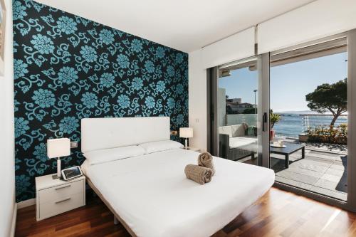 1 dormitorio con cama blanca y pared en blanco y negro en Vista Roses Mar - Canyelles Petites Platja, en Roses
