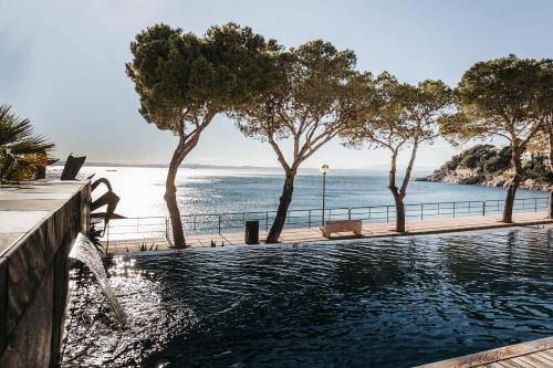 a swimming pool with a view of the ocean at Vista Roses Mar - Canyelles Petites Platja in Roses