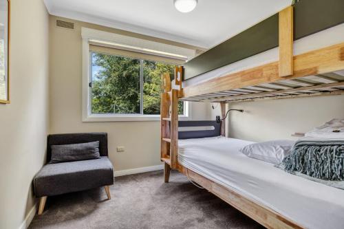a bedroom with two bunk beds and a chair at Wandi Bright View in Wandiligong