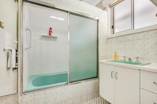 a bathroom with a glass shower and a sink at Wandi Bright View in Wandiligong