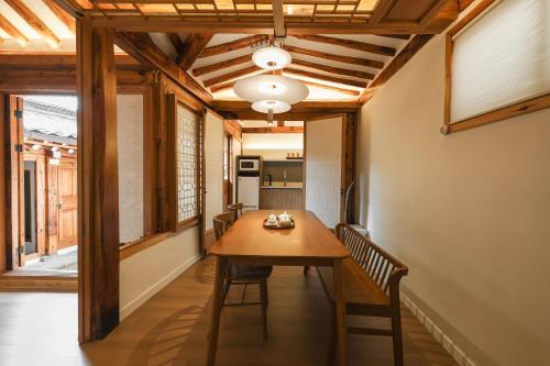 uma sala de jantar com uma mesa de madeira e cadeiras em Luxury hanok with private foot bathtub - SN10 em Seul