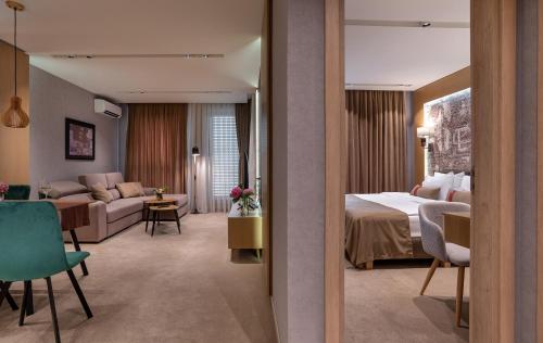 ein Hotelzimmer mit einem Bett und einem Wohnzimmer in der Unterkunft City Park Inn Apartment Cortona in Plowdiw