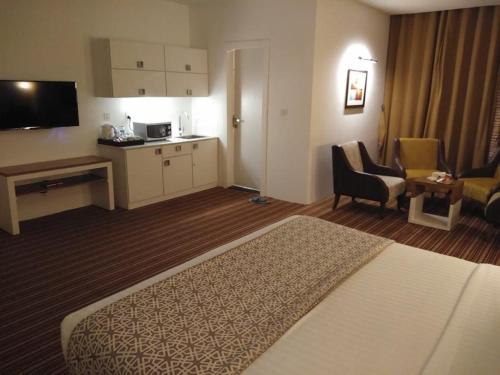 een hotelkamer met een bed en een keuken bij West Inn Hotel Faisalabad in Faisalabad
