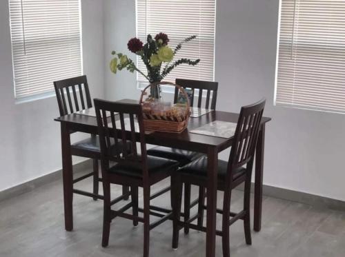 una mesa de comedor con sillas y una cesta de flores en Leona's Hidden Adventure home en Donoe