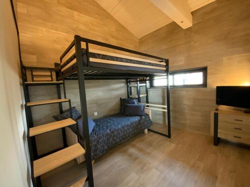 a room with a bunk bed and a tv at Artik chalet avec vue à 180 degrés et piscine in Les Angles