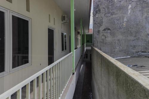 an empty hallway of a building next to a wall at KoolKost Syariah near Alun Alun Sidoarjo in Sidoarjo