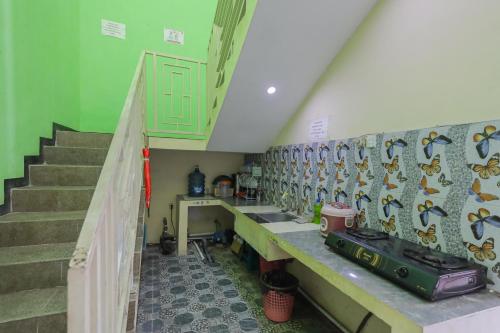 a room with a staircase and a wall with fish tiles at KoolKost Syariah near Alun Alun Sidoarjo in Sidoarjo