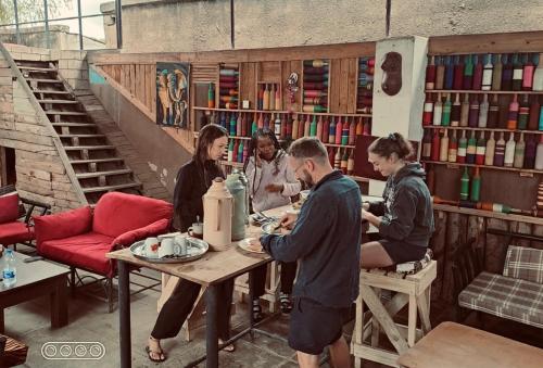 a group of people sitting at a table in a room at Arusha Safari Hostel in Arusha