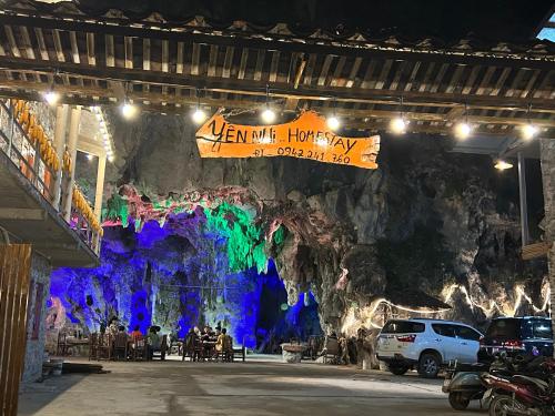 a group of people sitting in front of a rock wall at Yen Nhi Homestay Ban Gioc in Cao Bằng
