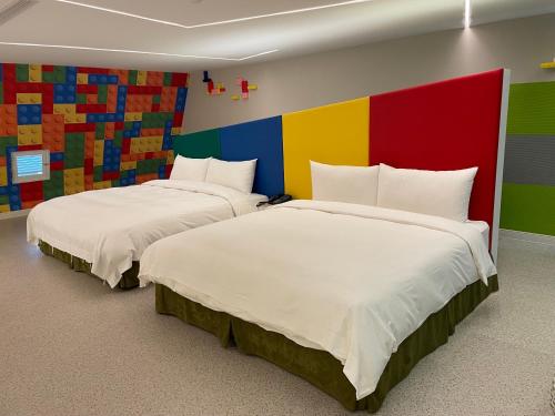 two beds in a room with a colorful wall at Ya Nold Hot Spring Hotel in Jiaoxi