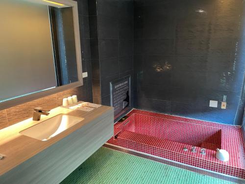 a bathroom with a sink and a red shower at Ya Nold Hot Spring Hotel in Jiaoxi