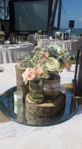 a centerpiece of flowers in vases on a table at Villa Samudra Luxury Beachfront in Ketewel