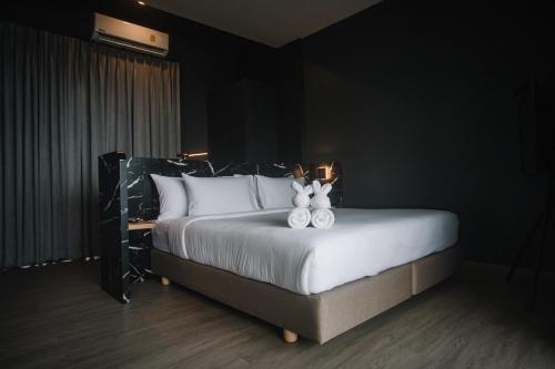 a bedroom with a bed with two stuffed animals on it at INN BLOG HOTEL Pakbara in Satun