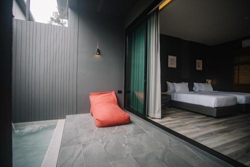 INN BLOG HOTEL Pakbara في ساتون: غرفة بسريرين ومخدة برتقال على الأرض