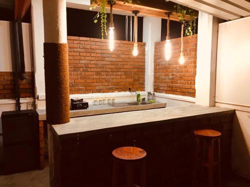 a kitchen with a counter with two stools and a sink at Remli Villa in Kandy