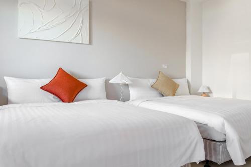 two white beds sitting next to each other in a room at Taitung Chun Yang Inn in Taitung City