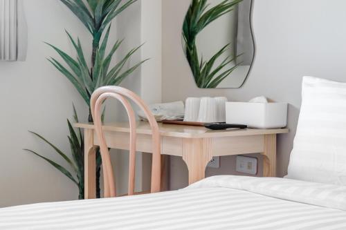 a bedroom with a desk with a chair and a mirror at Taitung Chun Yang Inn in Taitung City