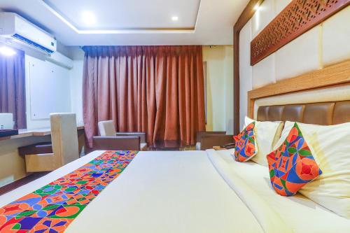 a hotel room with a bed and a desk at FabHotel Keerthi's Anupama - Nr Indira Gandhi Stadium in Vijayawāda