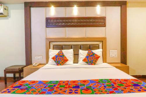 a bedroom with a large bed with a colorful bedspread at FabHotel Keerthi's Anupama - Nr Indira Gandhi Stadium in Vijayawāda