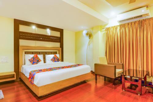 een slaapkamer met een groot bed, een tafel en een bureau bij FabHotel Keerthi's Anupama Governor Peta in Vijayawāda