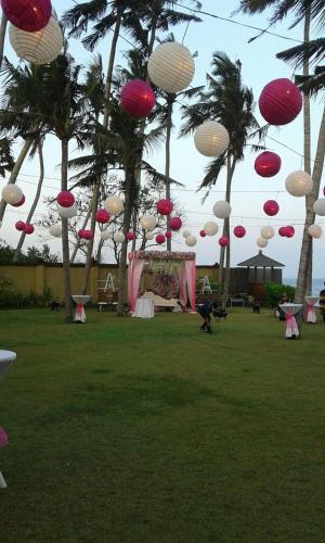 a group of pink and white lanterns hanging from trees at Villa Samudra Luxury Beachfront in Ketewel