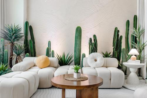 a living room with white furniture and green plants at Taitung Chun Yang Inn in Taitung City