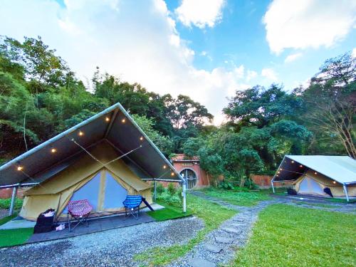 a tent with chairs in a field of grass at Lapopo in Keelung