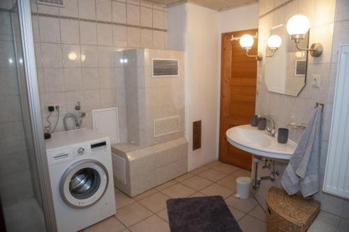 uma casa de banho com uma máquina de lavar roupa e um lavatório em Ruhe-haus em Grafenau