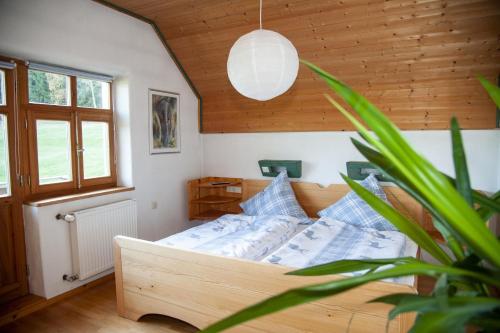 um quarto com uma cama e um vaso de plantas em Ruhe-haus em Grafenau