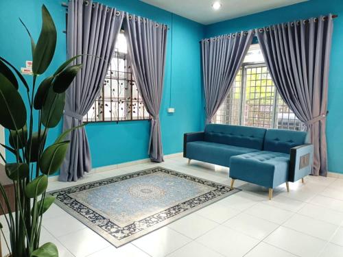 a blue living room with a blue couch and windows at Homestay Kemaman Private Pool Fyna in Kemaman