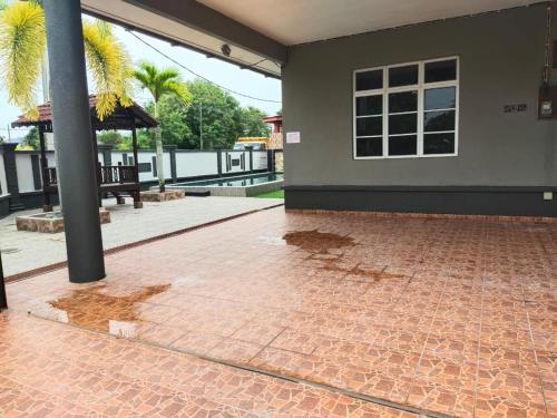 a patio with a brick floor and a building at Homestay Kemaman Private Pool Fyna in Kemaman