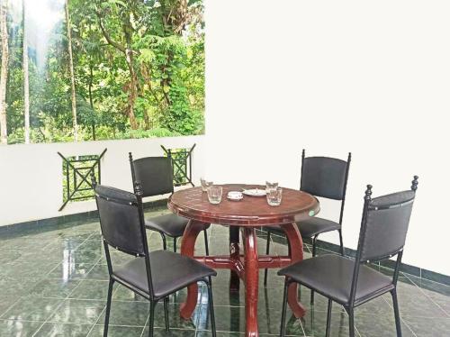 uma mesa de madeira com cadeiras e uma mesa e uma mesa em 4Seasons Holiday Home em Ratnapura