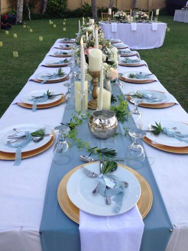 a long blue table with plates and candles on it at Villa Samudra Luxury Beachfront in Ketewel
