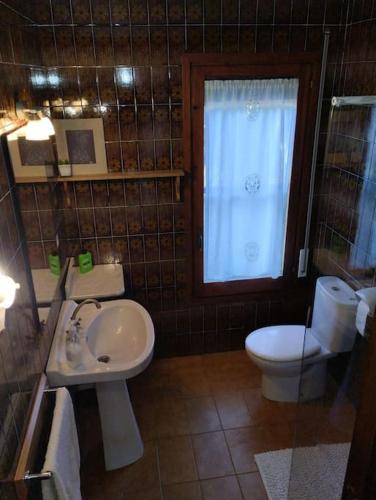 een badkamer met een wastafel, een toilet en een raam bij Casa de camp prop de la Costa Brava in Romanyá de la Selva