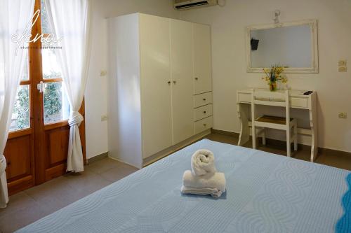 a room with a statue of a dog sitting on a bed at Elena Studios & Apartments in Piso Livadi